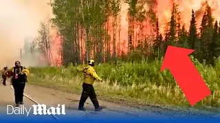 Firefighters run away from massive wildfire in Banff National `Park, Alberta Canada