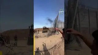 Palestinian bulldozer removes the separation wall on the Gaza Strip border