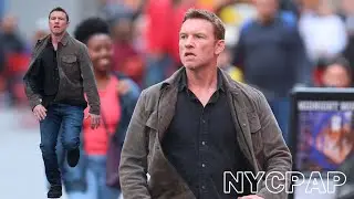 Sam Worthington runs through Times Square as he films RELAY in New York City