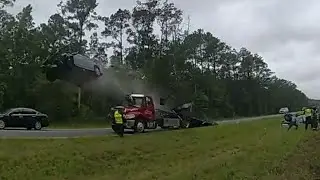 Driver sends car flying off parked tow truck ramp in front of police | Body cam