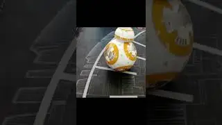 Круглый робот из звездных войн BB-8 бьётся головой об стену на выставке роботов. Personal Droid