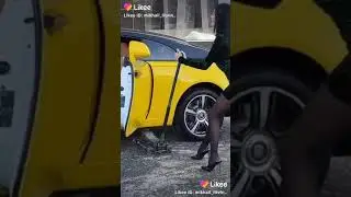 девушка в мини поднимает авто домкратом , парень сидит в машине