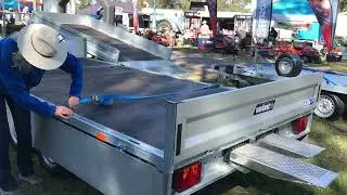 Woman showing how to apply straps to trailer