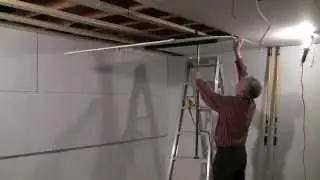 One man drywall installation on ceiling