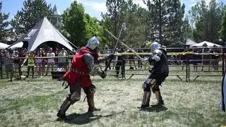 Medieval Knight breaks opponents helmet during full contact armored combat and knocks him down