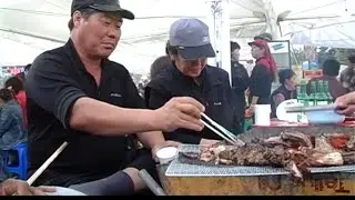 Street food - eat live squid. South Korea. Pochen: harvest festival, fair, Korean food.