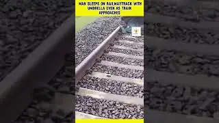 Man naps on railway track with umbrella while a train approaches. #infotainmentnews