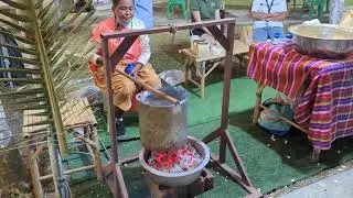 Making popcorn over a charcoal fire in Thailand