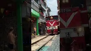 Train Navigates Through Bustling Train Street