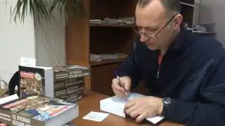 Адвокат Александр Васильев подписывает экземпляры книги 