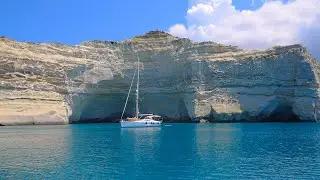 4K Dramatic Cliffs and Crystal Clear Water on the Greek island of Milos with Sail Boats Anchored