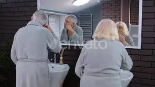 Senior Couple Man and Woman Brushing Teeth and Looking Into a Mirror at Luxury Bathroom at Home ...
