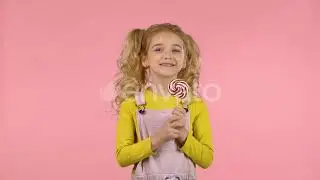 Beautiful Girl with a Lollipop in Studio on Pink Background | Stock Footage - Envato elements