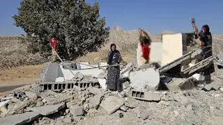 Susan collects scrap metal under the ruins of her house destroyed by the police.