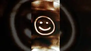 Смайлик на песке с цветной подсветкой. Smiley face on the sand with colored backlight.