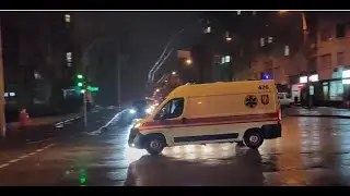 Автотранспорт. Автодороги. Скорая помощь с сиреной и мигалками мчится на прекрестке в центре Киева.
