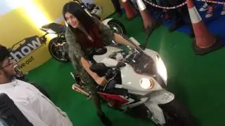 Girl reving superbike BMW s1000rr with akropovik set