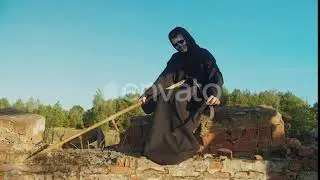 Grim Reaper Sharpening Rustic Scythe at Sunset | Stock Footage - Envato elements